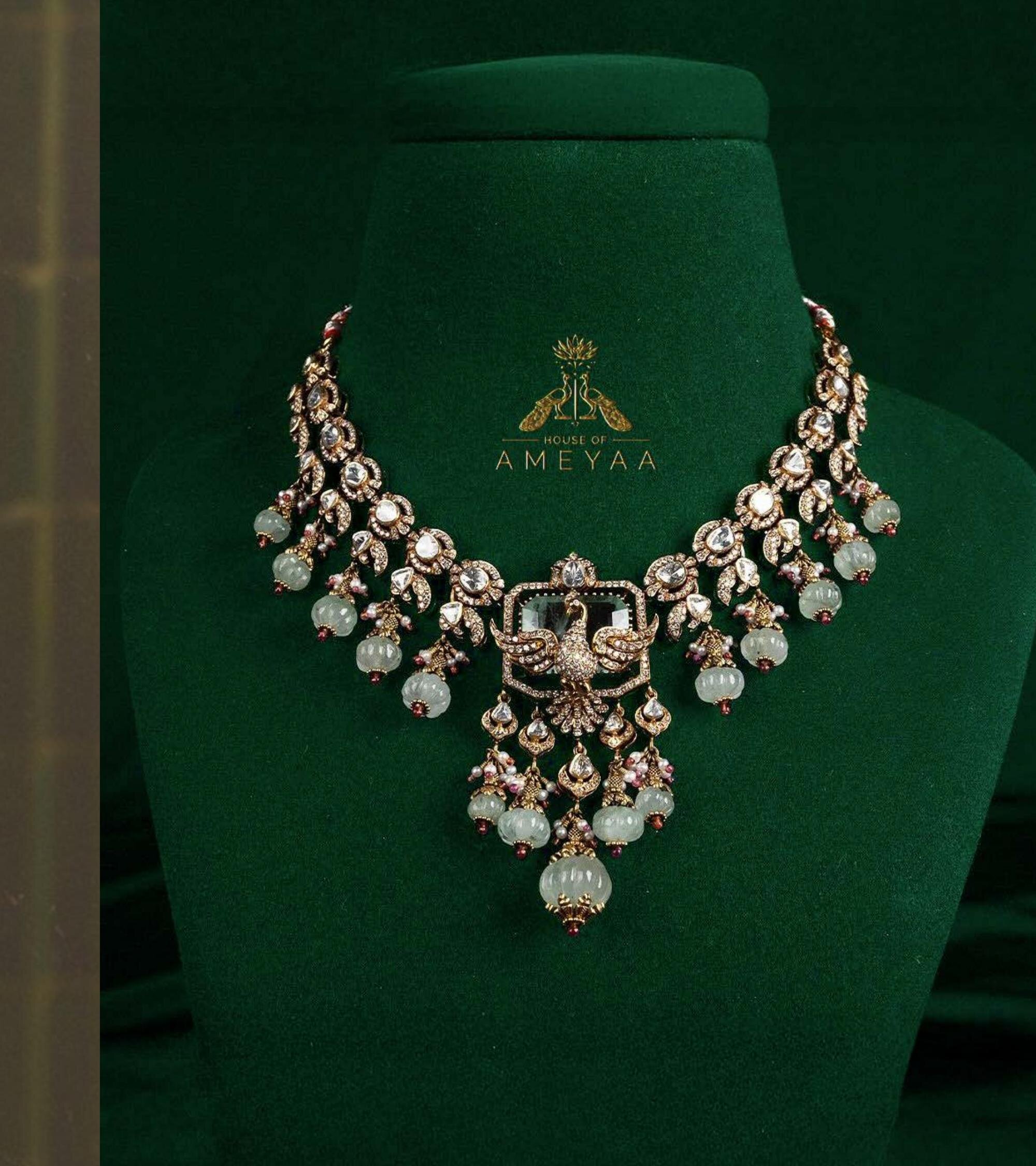A heritage gold and gemstone necklace displayed on green velvet