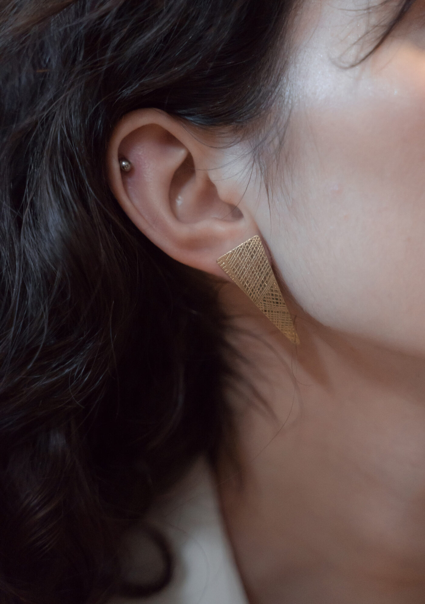 Gold geometric statement earring close-up